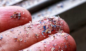 Close up side shot of microplastics lay on people hand.Concept of water pollution and global warming. Climate change idea.