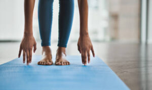 Shot of an unrecognisable woman practicing a yoga routine at home